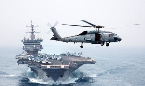 An HH-60H Sea Hawk helicopter assigned to the Dragonslayers of Helicopter Anti-Submarine Squadron (HS) 11 flies in front of the aircraft carrier USS Enterprise (CVN 65)