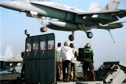 Landing Signal Officers on the LSO platform assist in another succesfull aircraft recovery on the flight deck